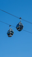 Obraz premium Modern Ropeway Cable Cars in Yokohama, Japan Against a Clear Blue Sky