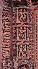 Carvings of various figures, including love-making couples, on the entrance of the ruined Jain...
