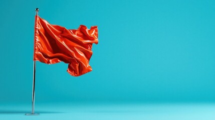 A photostock of a red flag fluttering in the wind against a clear blue sky.