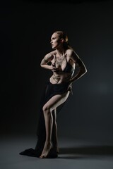 Fototapeta premium Artistic expression through dance and pose by a model in a dark studio setting