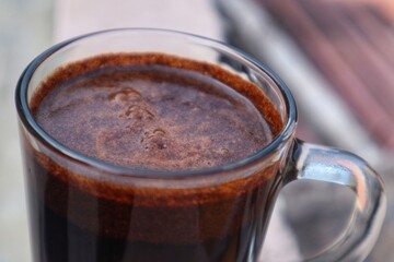 Black Coffee drink in a clear glass, close up view.