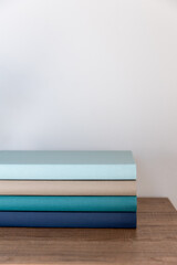 Neatly stacked colorful books on a wooden surface