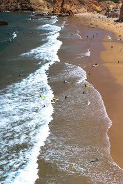Surfers on the waves at Praia do Tonel in Sagres, Algarve, Portugal