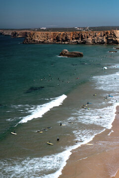 Surfers on the waves at Praia do Tonel in Sagres, Algarve, Portugal