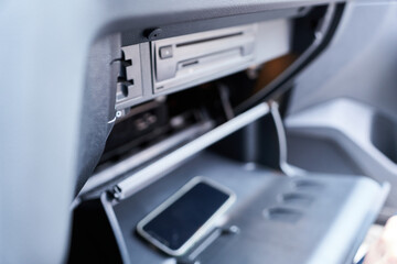 A close-up of a smartphone in a modern car. Smartphone in the glove compartment of a car.