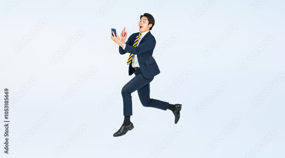 Aufkleber スマホを見ながらジャンプする若い男性ビジネスパーソンの全身写真（切り抜き背景透過pngも販売しております。作成者リンクから「png」で検索してください）