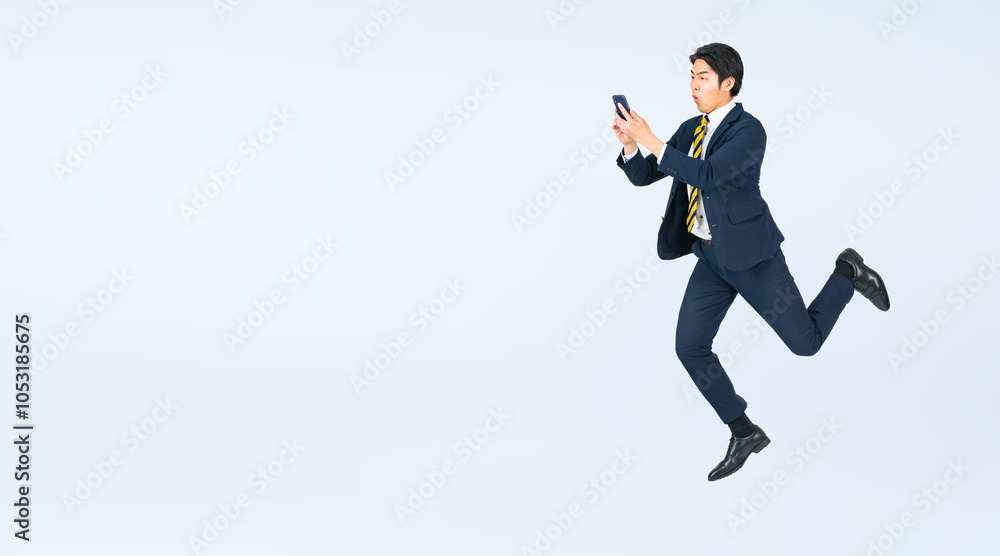 Aufkleber スマホを見ながらジャンプする若い男性ビジネスパーソンの全身写真（切り抜き背景透過pngも販売しております。作成者リンクから「png」で検索してください）