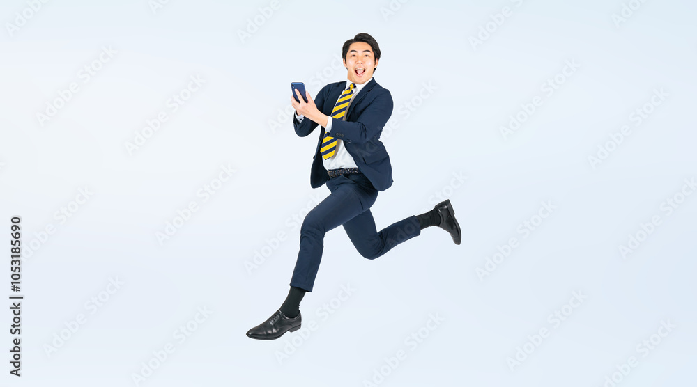 Aufkleber スマホを見ながらジャンプする若い男性ビジネスパーソンの全身写真（切り抜き背景透過pngも販売しております。作成者リンクから「png」で検索してください）