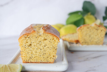 freshly baked homemade lemon poppy seed pound cake on white ceramic tray.