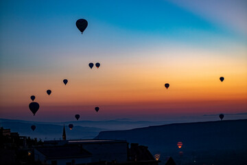 Views of Cappadocia, hot air balloons at dawn against the backdrop of tuff mountains and cave houses