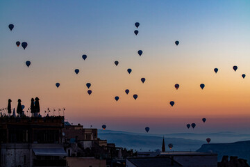 Views of Cappadocia, hot air balloons at dawn against the backdrop of tuff mountains and cave houses