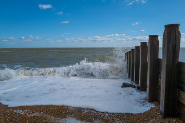 Breaking wave against a groyne with sea spray.