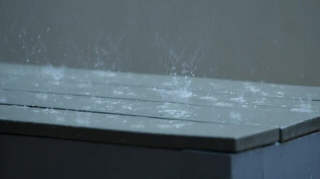 Wooden surface being hit with strong rainfall, close up