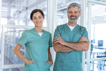 Two doctors standing in the clinic corridor and looking confident