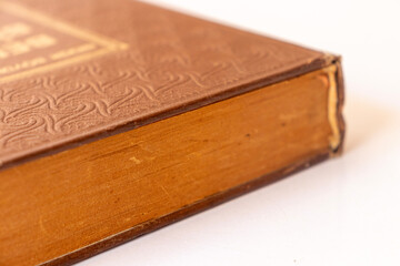 Damaged brown leather cover of a very old book. books standing horizontally and vertically. yellowed natural paper texture. isolated on white background. clean close-up.