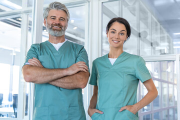 Fototapeta premium Two doctors standing in the clinic corridor and looking confident