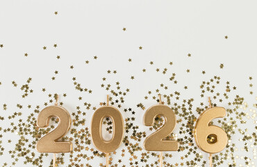 2026 Happy New Year. Top view of gold numbers, gold stars confetti on white background. Copy space,...