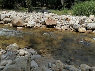 The view of a creek, the water is clear and rocky. Interesting place for a picnic.