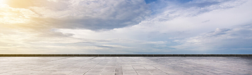 Cement floor view with blue sky and clouds in the background