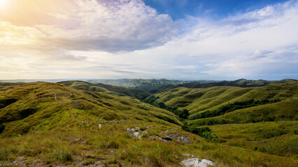Mountain range with blue sky and clouds in the background. The sky is clear and the clouds are fluffy
