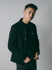 Fototapeta premium Stylish Young Man in Black Outfit Against Neutral Background