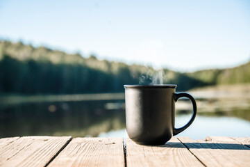 Cup of hot drink on nature background. Morning in the forest in nature with a hot drink