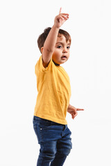 Two year old boy raises index finger on white background