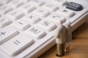 Senior couple are looking at white calculator on wooden table. Money financial management, pension,...