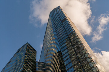 Angled view of modern skyscrapers in business district against blue sky. Looking Up high-rise office buildings.