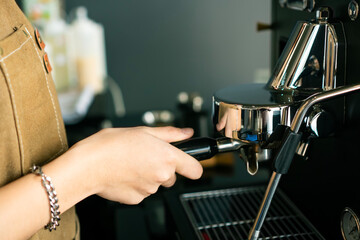 young asian girl barista is making coffee in a cafe using a drip coffee machine Produce high quality coffee 
