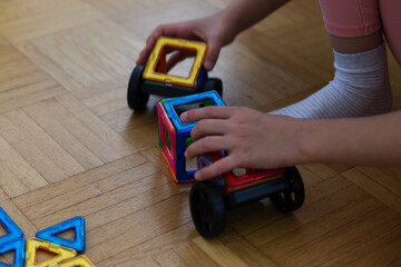 Fototapeta premium Children playing with colorful wooden blocks on the floor in the living room