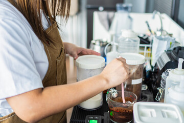 young asian girl barista is making coffee in a cafe using a drip coffee machine Produce high quality coffee 