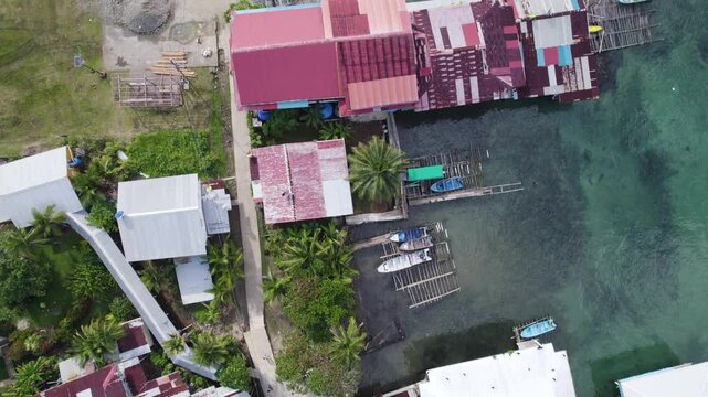 Aerial topdown view along stilt houses by turquoise water in Bastimentos Island, Panama