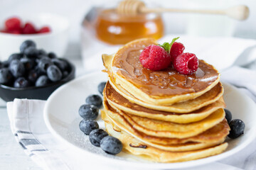 Pancakes with fresh berries and honey. on a wooden background. breakfast