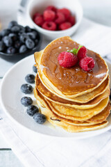 Pancakes with fresh berries and honey. on a wooden background. breakfast