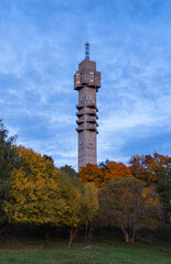 Obraz premium Concrete Radio Tower in Autumn Forest in the foreground