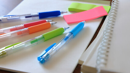 Colorful pens, notepads, and reference books on the desk studying for qualifications