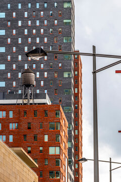 An intriguing city scene featuring a prominent water tower amidst a collection of varied architectural styles, epitomizing urban diversity and originality in Rotterdam