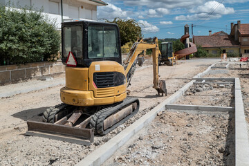 Escavadora em ação na preparação de terreno para infraestrutura urbana e melhoramentos de estrada e na construção de passeios numa zona residencial