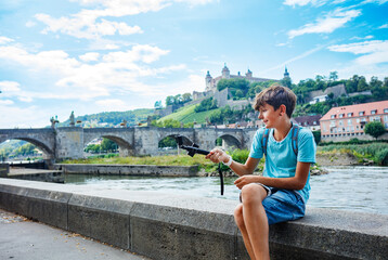 Happy teenager with camera explores historic city of Wurzburg