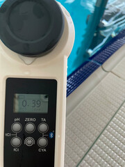 Digital water tester provides accurate readings of crystal clear water with beige tiled floor,...