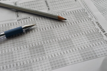 Blank OMR sheet with pencil pen NEET, JEE, exam centre hall student teacher time important leak paper question marks marking tick scam cheating AIR rank coaching course