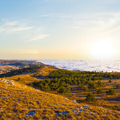 wide mountain valley in mist and clouds  at the sunset