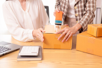 Small business startup, SME owner, Asian woman checking online orders, selling products at home, working with boxes and laptop, freelancer