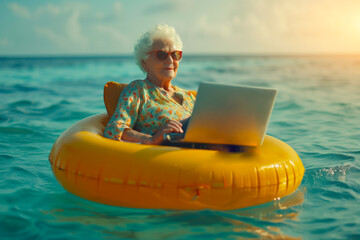 grandmother miss lady seniora in sunglasses and a panama hat with laptop swims on a ring in the sea