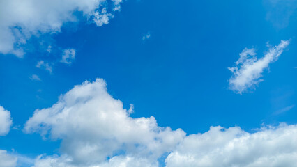 Bright Blue Sky with Scattered White Clouds
, creating a calm and serene atmosphere, perfect for representing clear weather and peaceful outdoor scenery.
