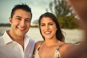 Naklejka premium Beach, outdoor and portrait of couple, selfie and bonding in vacation, travel and memory for happy people. Trip, man and woman with smile for romance, picture and photography for date and California