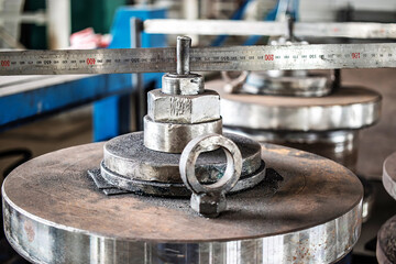 Metal weights on a machine ready for calibration in a manufacturing facility during the morning hours