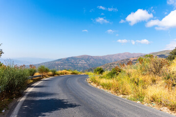 Empty road leading towards mountains against the sky in Tizi Ouzou, Algeria. 