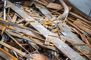 Metal scraps collected for recycling process in a cluttered industrial yard during daylight hours